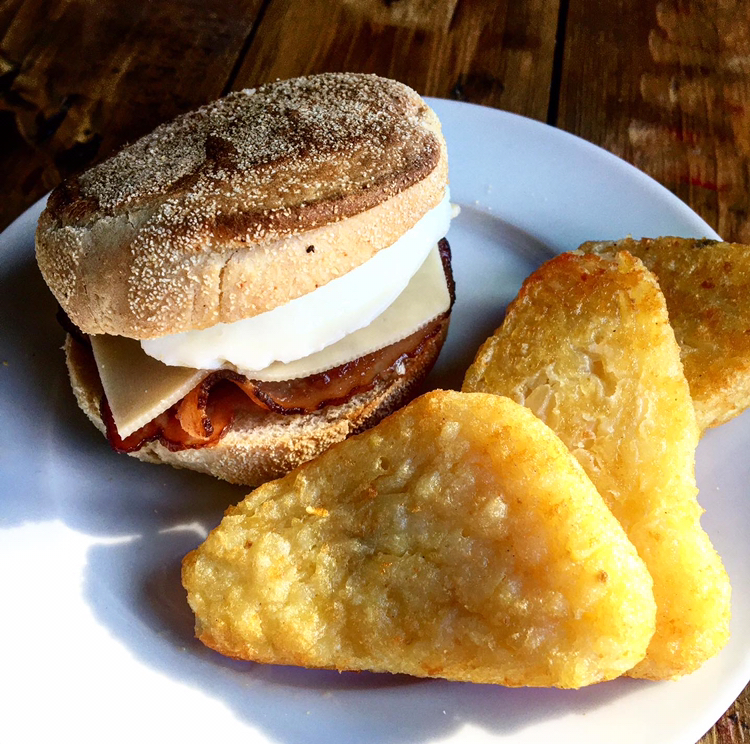 Egg & bacon filed muffin served with hash browns