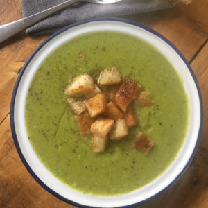 Bowl of minted pea soup with croutons on